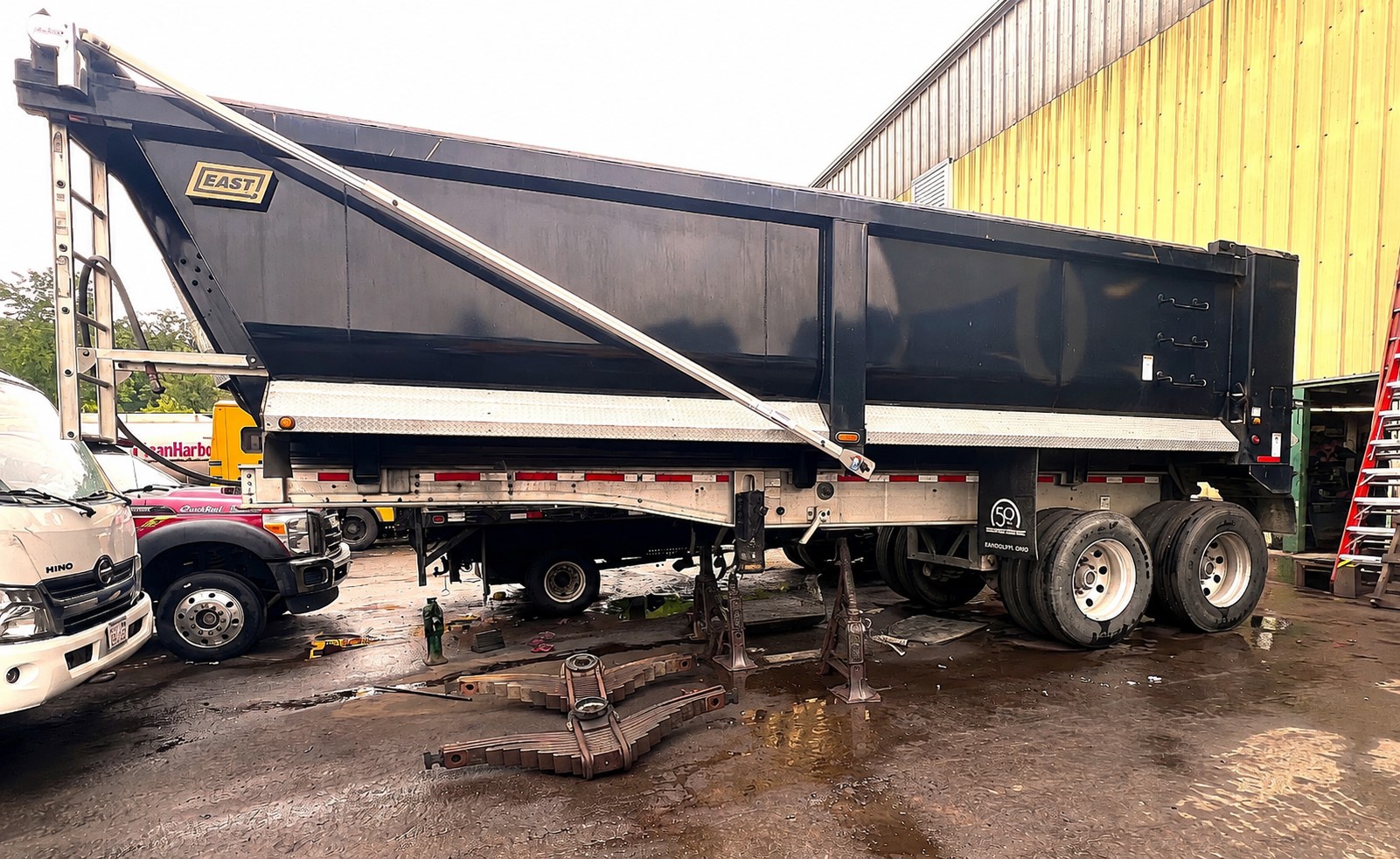 Heavy-duty trailer with leaf spring suspension removed for repair at Palmer Spring